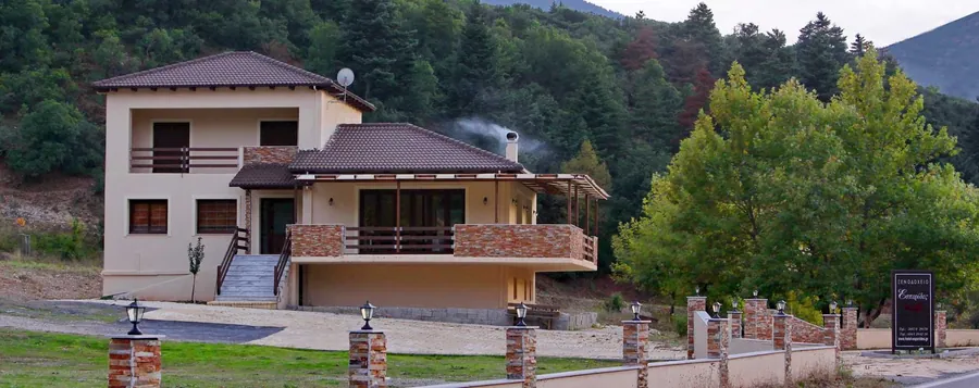 Η αίθουσα πρωινού με ξύλινη οροφή, στρωμένα τραπέζια και αναμμένο τζάκι